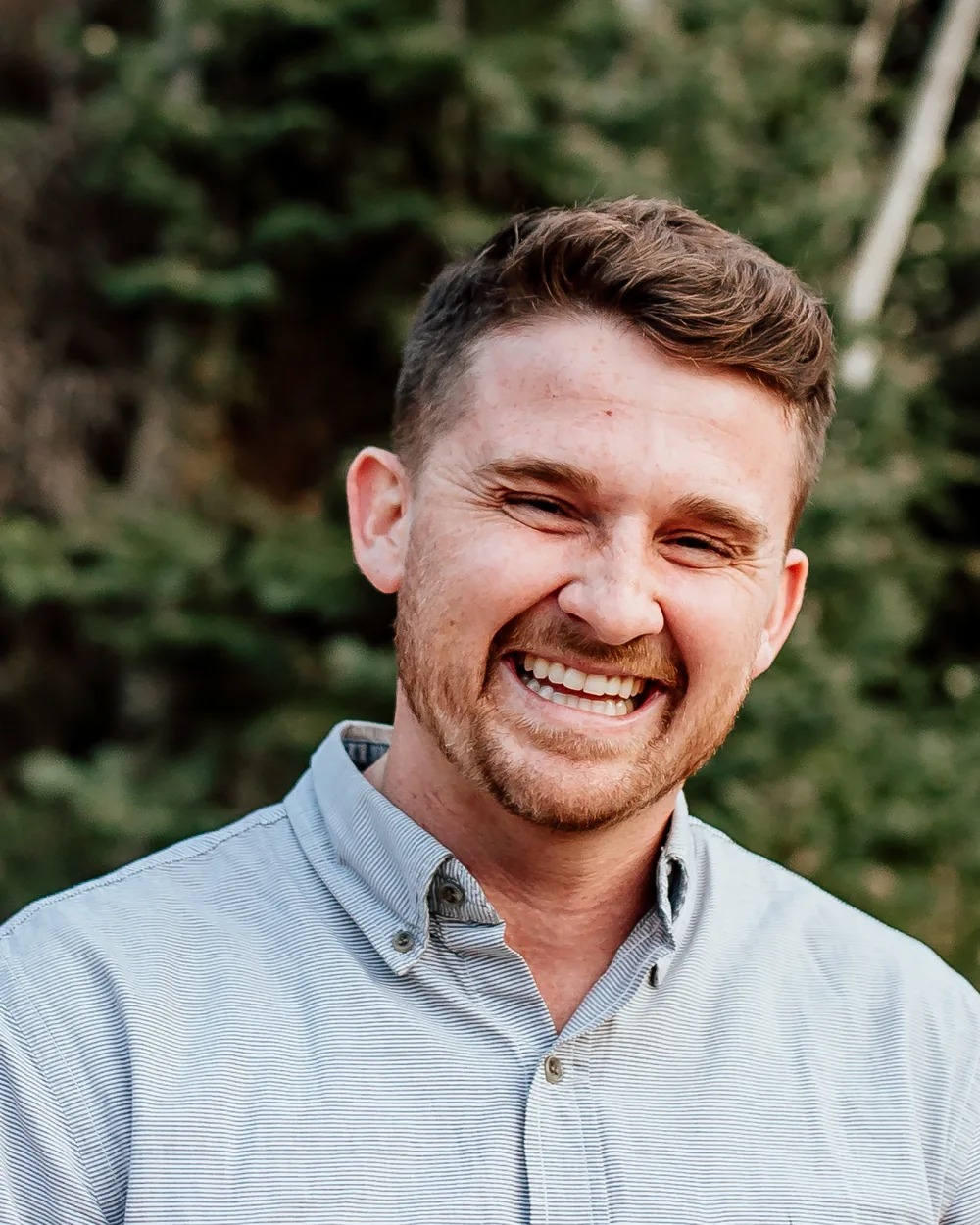 Dr. Brock Bennion, DDS, laughing outdoors — a warm candid of the Old Betsy Dental dentist